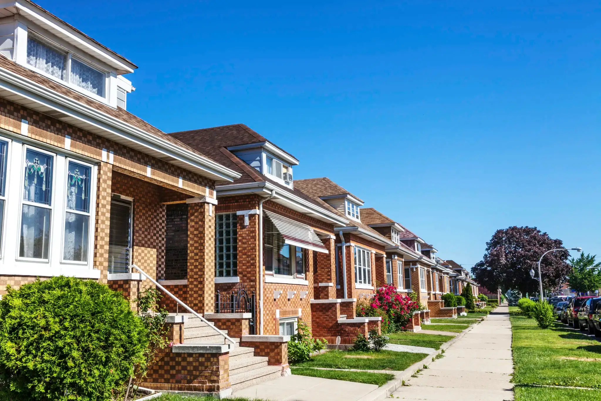 A row of brick houses under a clear blue sky.